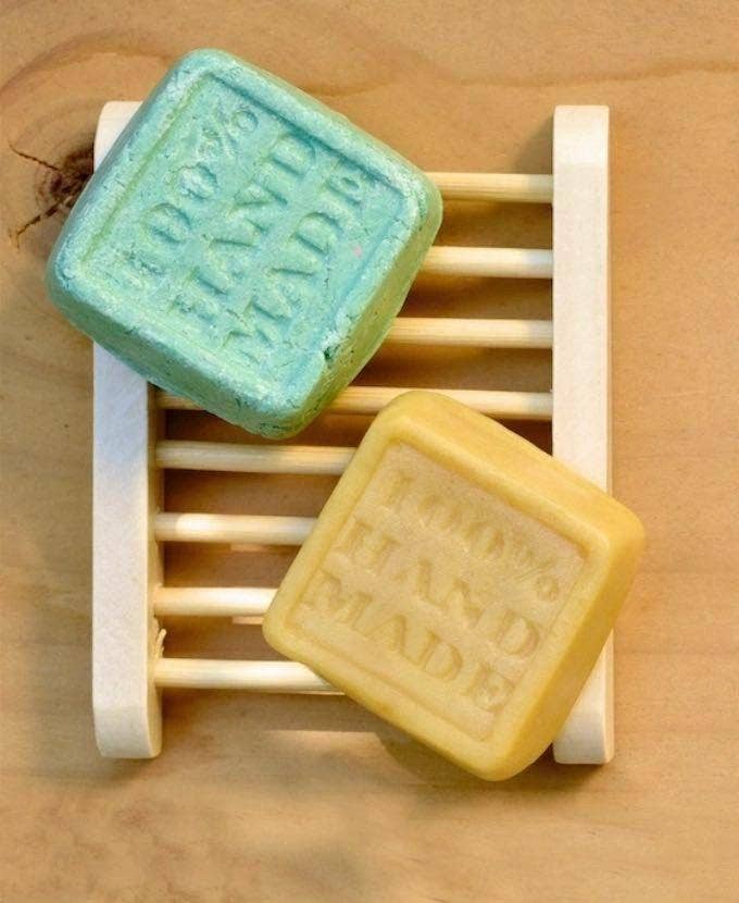 image of bamboo soap tray with a shampoo bar and conditioner bar sitting on top.