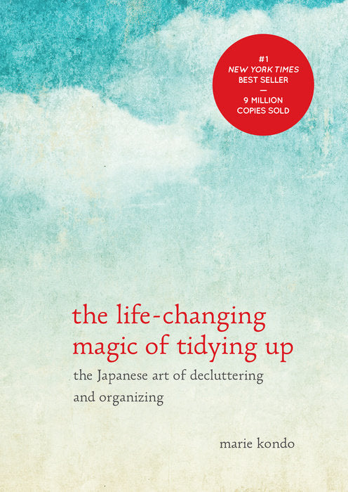Image of front cover of Marie Kondo's #1 New York Wimes Best Seller  Book . The Book title on the front is "The life-changing Magic of Tidying Up - the Japanese art of Decluttering and Organizing" the graphic on the front looks a bit like watercolor clouds.