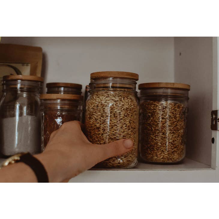 Image of several mason jars with dry goods, all have bamboo lids.