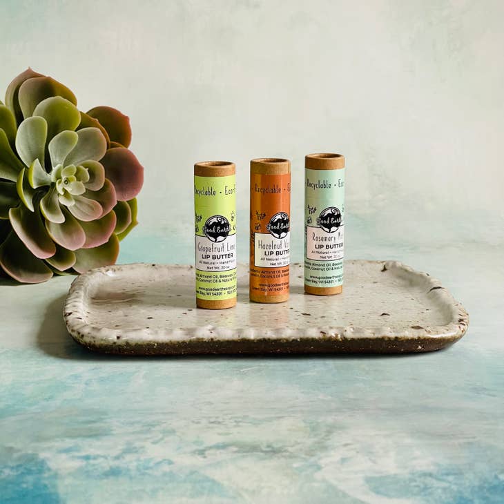 Image of three different flavored Lip butters standing upright on a small tray. 