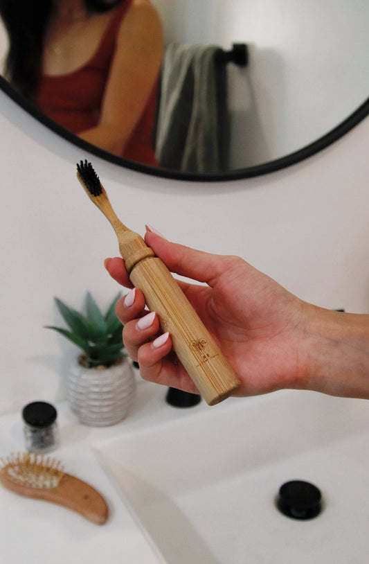 image of hand holding bamboo toothbrush