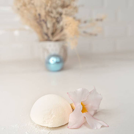 image of shower steamer out of packaging next to a flower