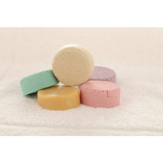 Image of 5 unpackaged shampoo and conditioner bars on a towel